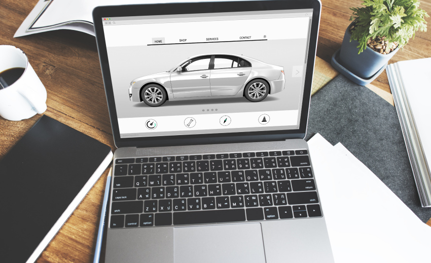 Laptop on wooden desk buying a car online